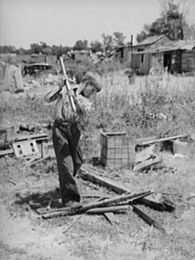 Boy-living-in-Mays-Avenue-camp-Oklahoma-City-Oklahoma-chopping-wood.jpg